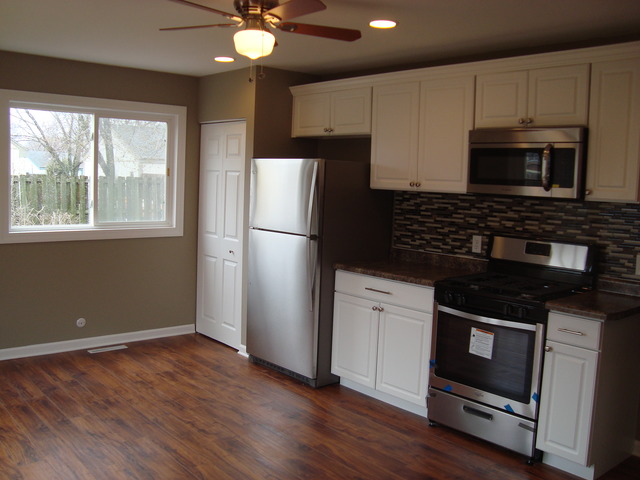 151 Heathgate Road Montgomery, IL 60538 - Photo 7 of 23 a kitchen with granite countertop white cabinets appliances and a window