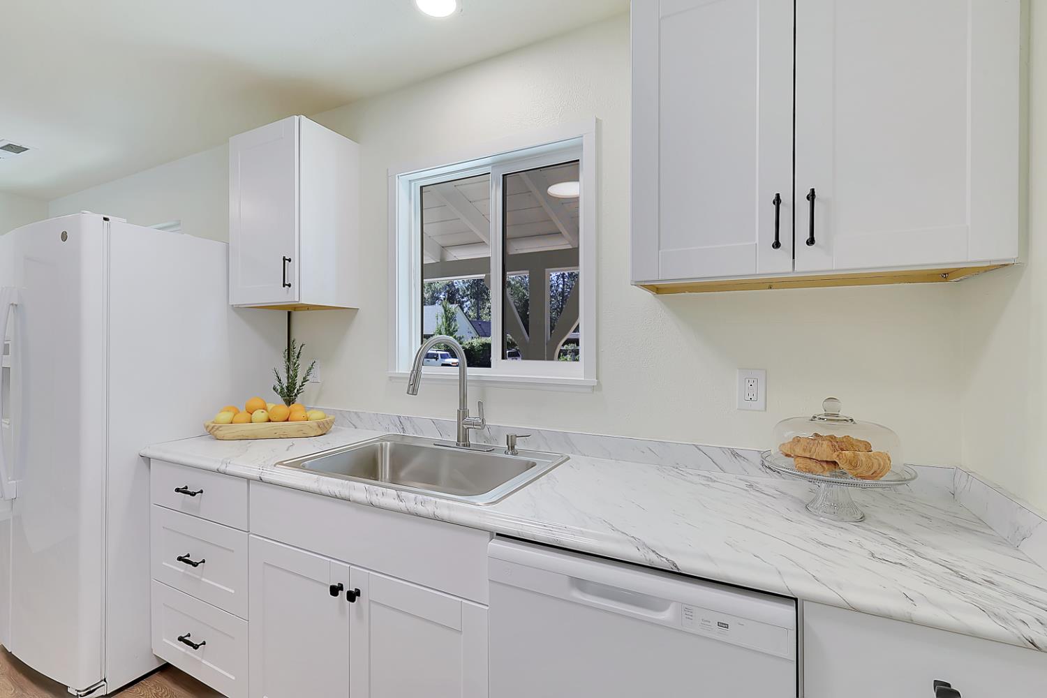 10673 Alta Street Grass Valley, CA 95945 - Photo 13 of 38 a kitchen with white cabinets and a sink