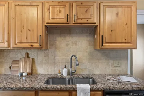 a kitchen with granite countertop a sink and cabinets