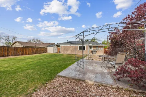 a view of a house with backyard and sitting area