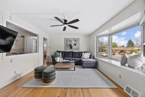 a living room with furniture a flat screen tv and a large window