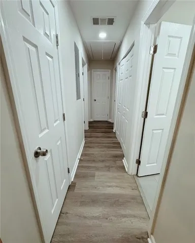 a view of a hallway with wooden floor and staircase