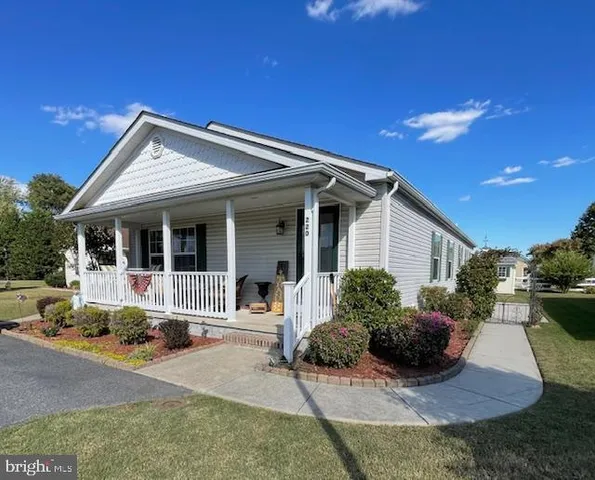 a front view of a house with porch and garden