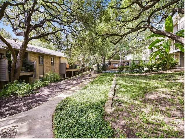 a yellow building with trees in front of it