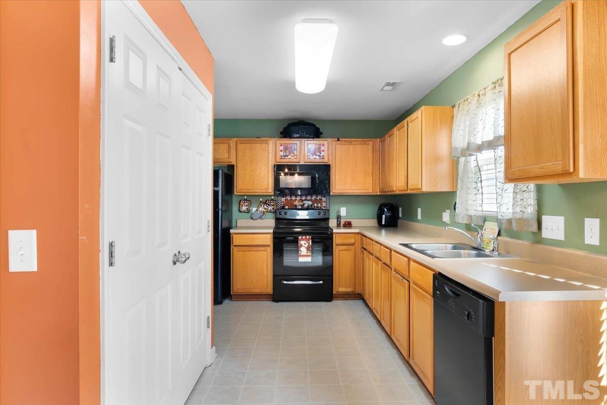 4262 Dalcross Road Raleigh, NC 27610 - Photo 11 of 27 a kitchen with stainless steel appliances granite countertop a stove a sink and a refrigerator