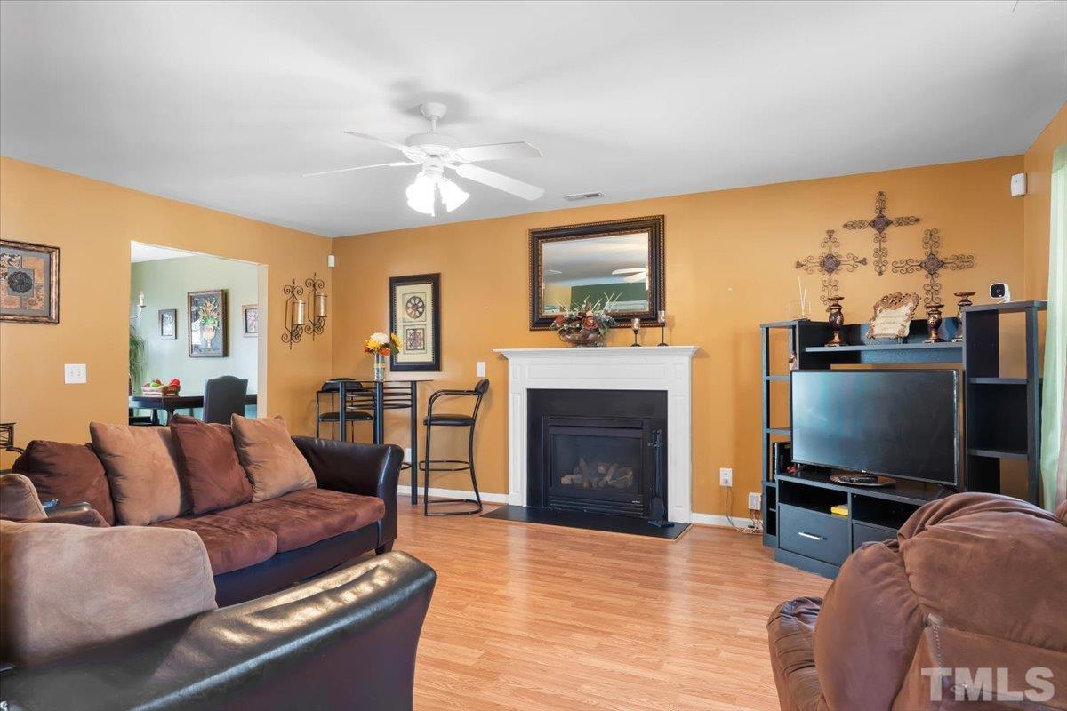 4262 Dalcross Road Raleigh, NC 27610 - Photo 5 of 27 a living room with furniture a flat screen tv and a fireplace