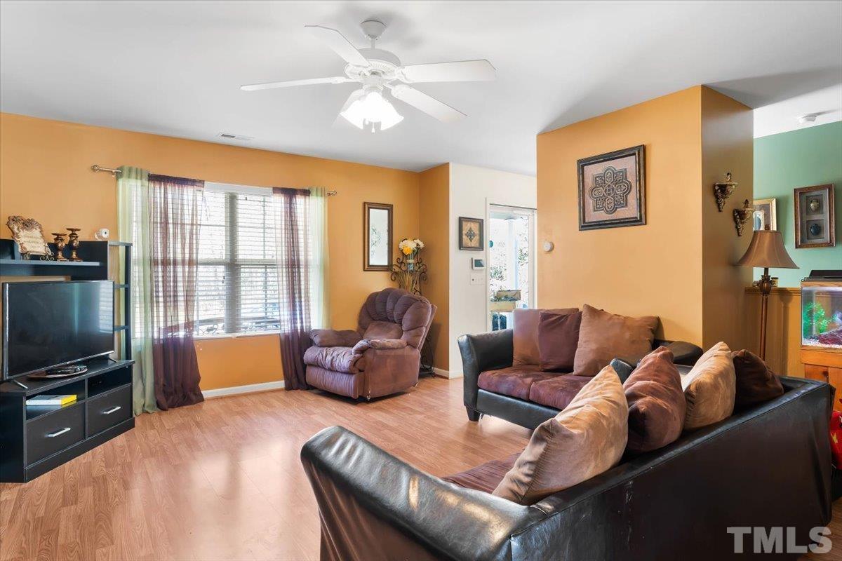 4262 Dalcross Road Raleigh, NC 27610 - Photo 8 of 27 a living room with furniture a flat screen tv and a large window