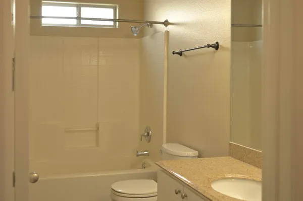 a bathroom with a granite countertop toilet and a shower