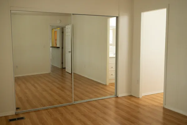 a view of a room with wooden floor and a bathroom