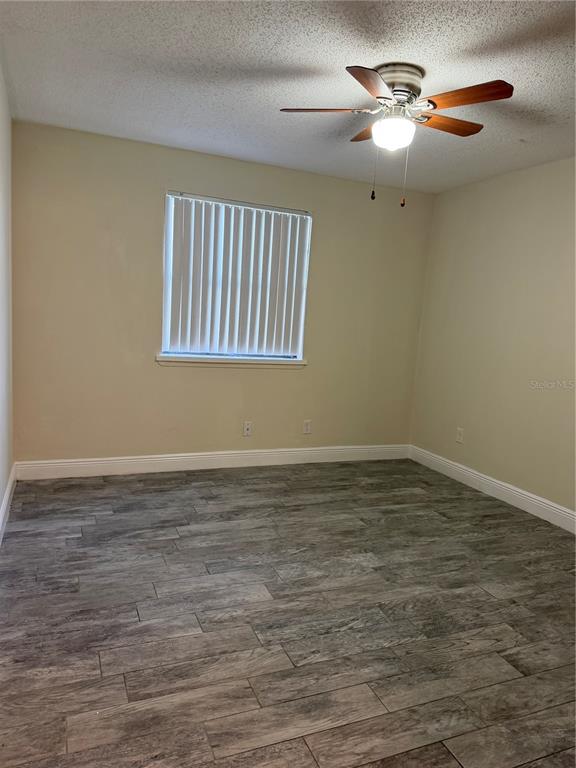 7409 Abonado Road, Unit 7409 Tampa, FL 33615 - Photo 11 of 25 a view of an empty room with chandelier fan and wooden floor