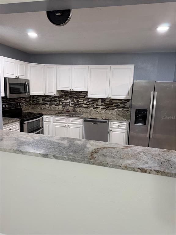 7409 Abonado Road, Unit 7409 Tampa, FL 33615 - Photo 4 of 25 a kitchen with stainless steel appliances granite countertop a sink a stove and a microwave