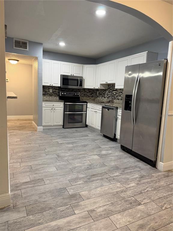 7409 Abonado Road, Unit 7409 Tampa, FL 33615 - Photo 5 of 25 a kitchen with stainless steel appliances kitchen island granite countertop a refrigerator and a stove top oven