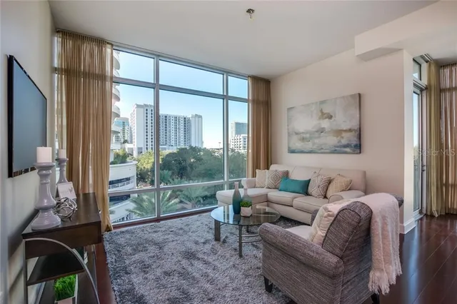 a living room with furniture and a floor to ceiling window