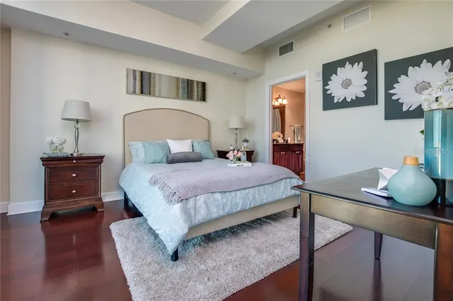 a bedroom with a bed and wooden floor