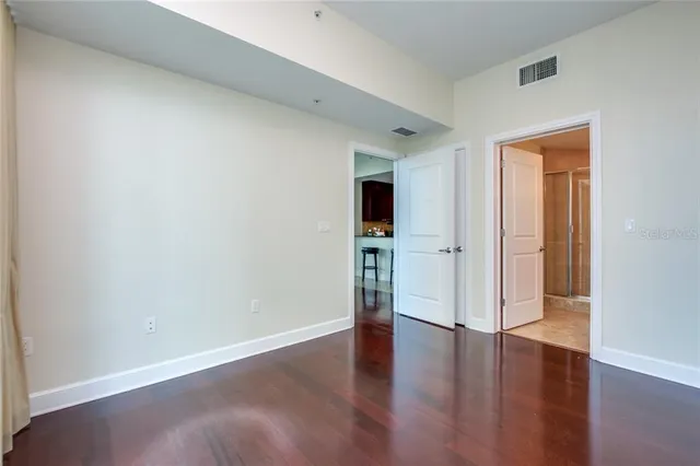 a view of empty room with wooden floor