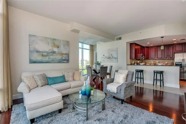 a living room with furniture and a wooden floor