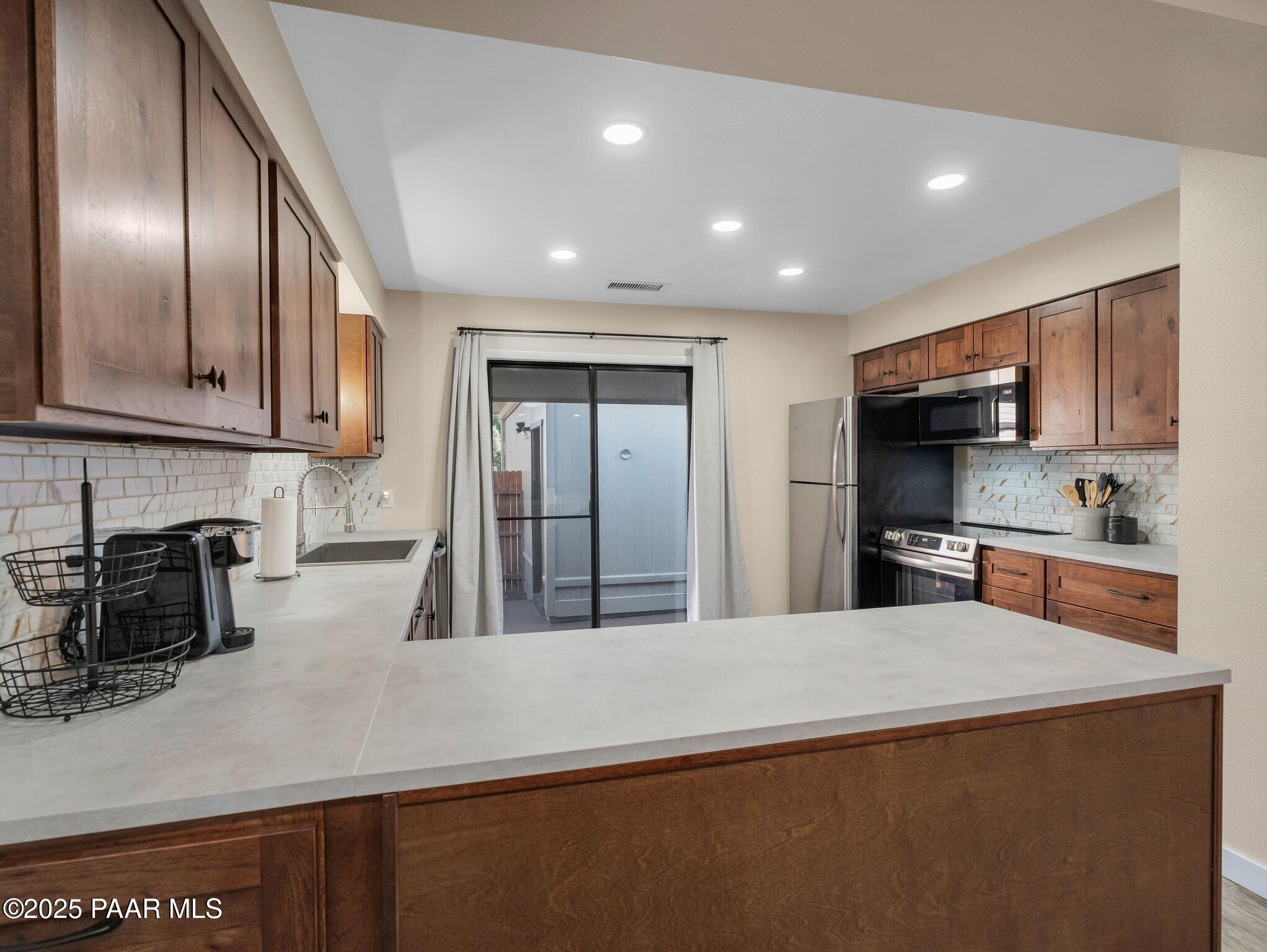 352 Rim Rock Circle, Unit 2 Prescott, AZ 86303 - Photo 12 of 25 a kitchen with stainless steel appliances granite countertop a refrigerator a stove top oven a sink and dishwasher