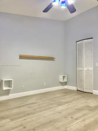 a view of an empty room with wooden floor and windows