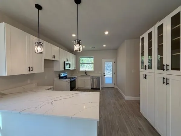 a large kitchen with kitchen island a island a sink stainless steel appliances and cabinets