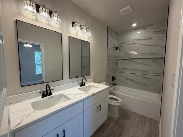 a bathroom with a double vanity sink toilet and shower