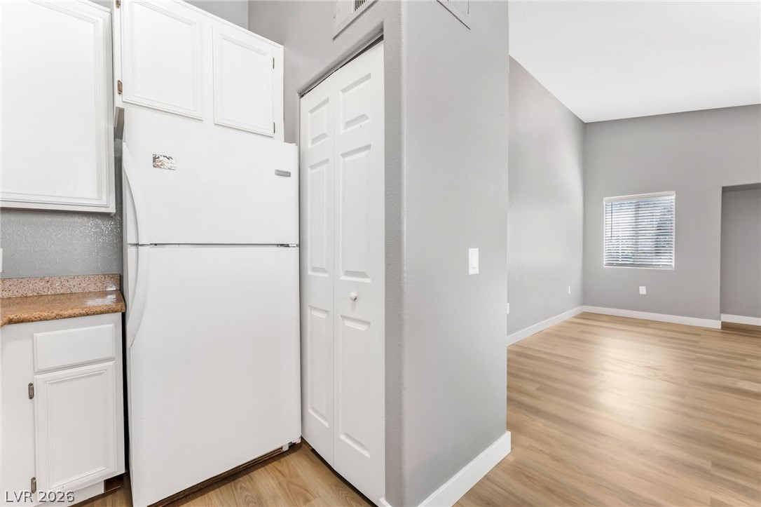 3318 North Decatur Boulevard, Unit 2152 Las Vegas, NV 89130 - Photo 13 of 58 A compact kitchen area opens into an adjacent living space with wood-look flooring.