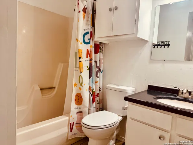 a bathroom with a toilet and a shower curtain