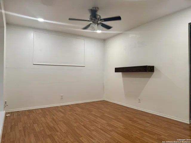 a view of empty room with wooden floor