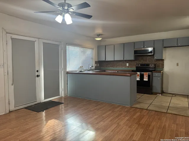 a kitchen with stainless steel appliances granite countertop a refrigerator a sink a stove and oven