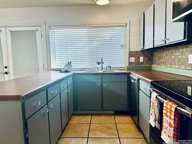 a kitchen with stainless steel appliances granite countertop a sink stove and cabinets