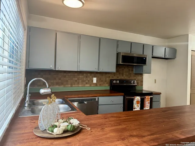 a kitchen with a sink and a stove top oven