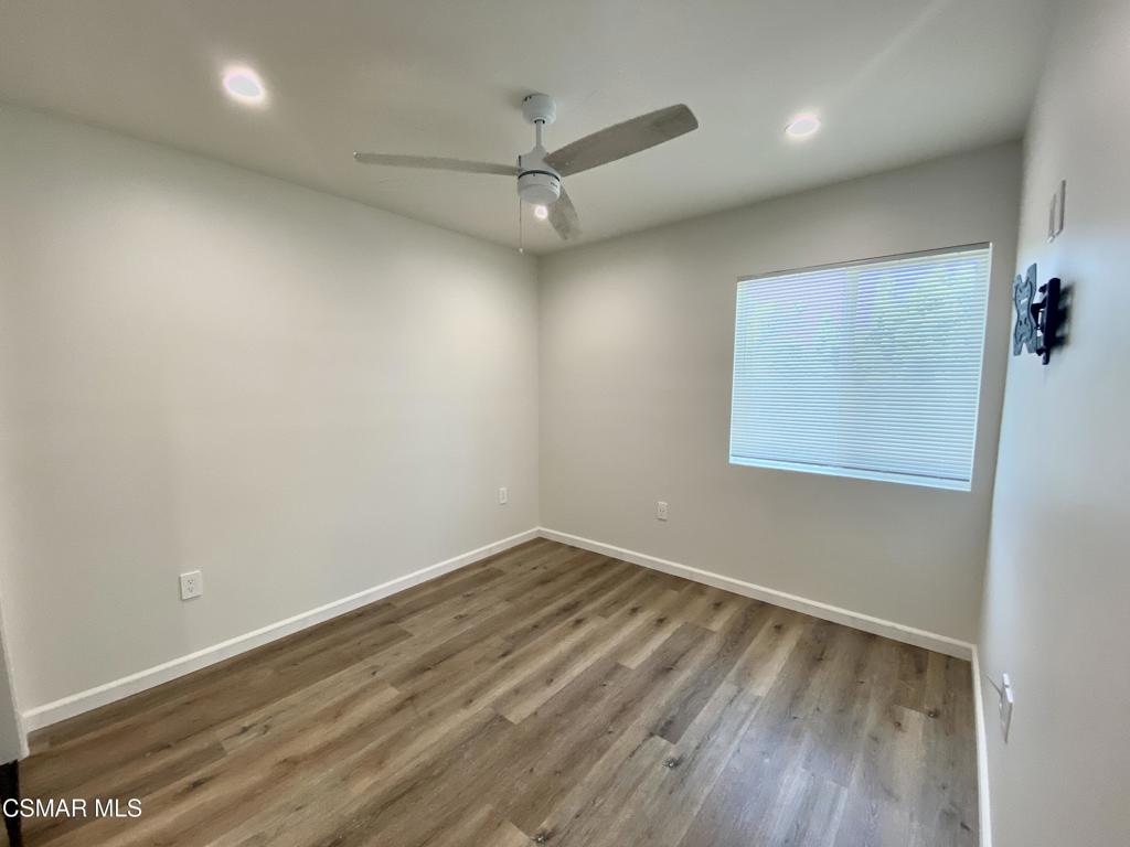 423 Saratoga Street, Unit B Fillmore, CA 93015 - Photo 14 of 20 an empty room with a ceiling fan and wooden floor