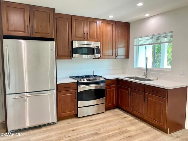 a kitchen with granite countertop wooden cabinets and stainless steel appliances