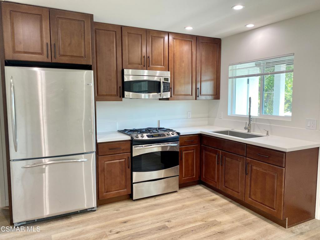 423 Saratoga Street, Unit B Fillmore, CA 93015 - Photo 8 of 20 a kitchen with granite countertop wooden cabinets and stainless steel appliances