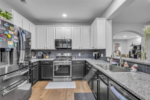 a kitchen with stainless steel appliances granite countertop a sink stove microwave and cabinets