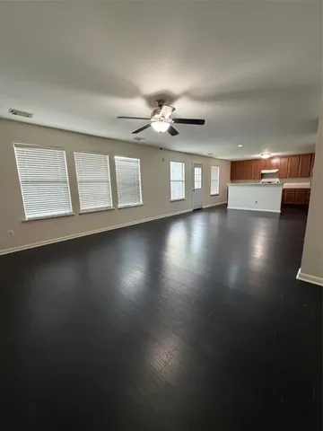a view of a livingroom with wooden floor and a ceiling fan
