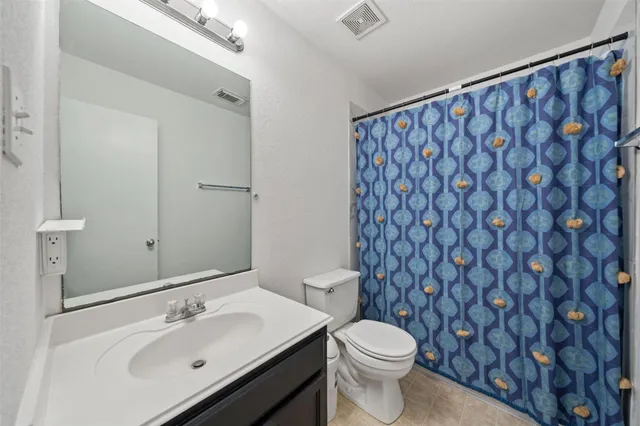 a bathroom with a sink a toilet and a large mirror