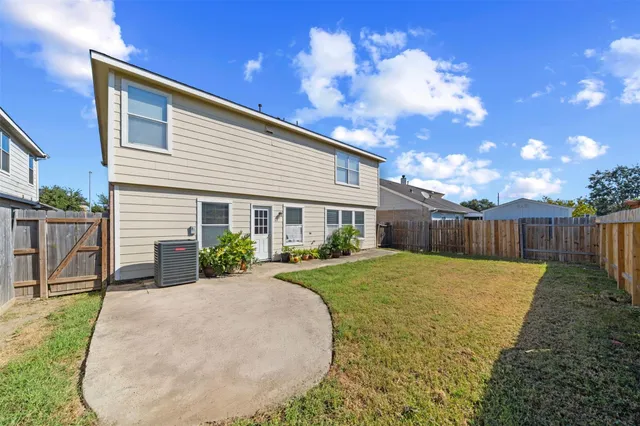 a view of backyard of house with wooden deck and outdoor seating