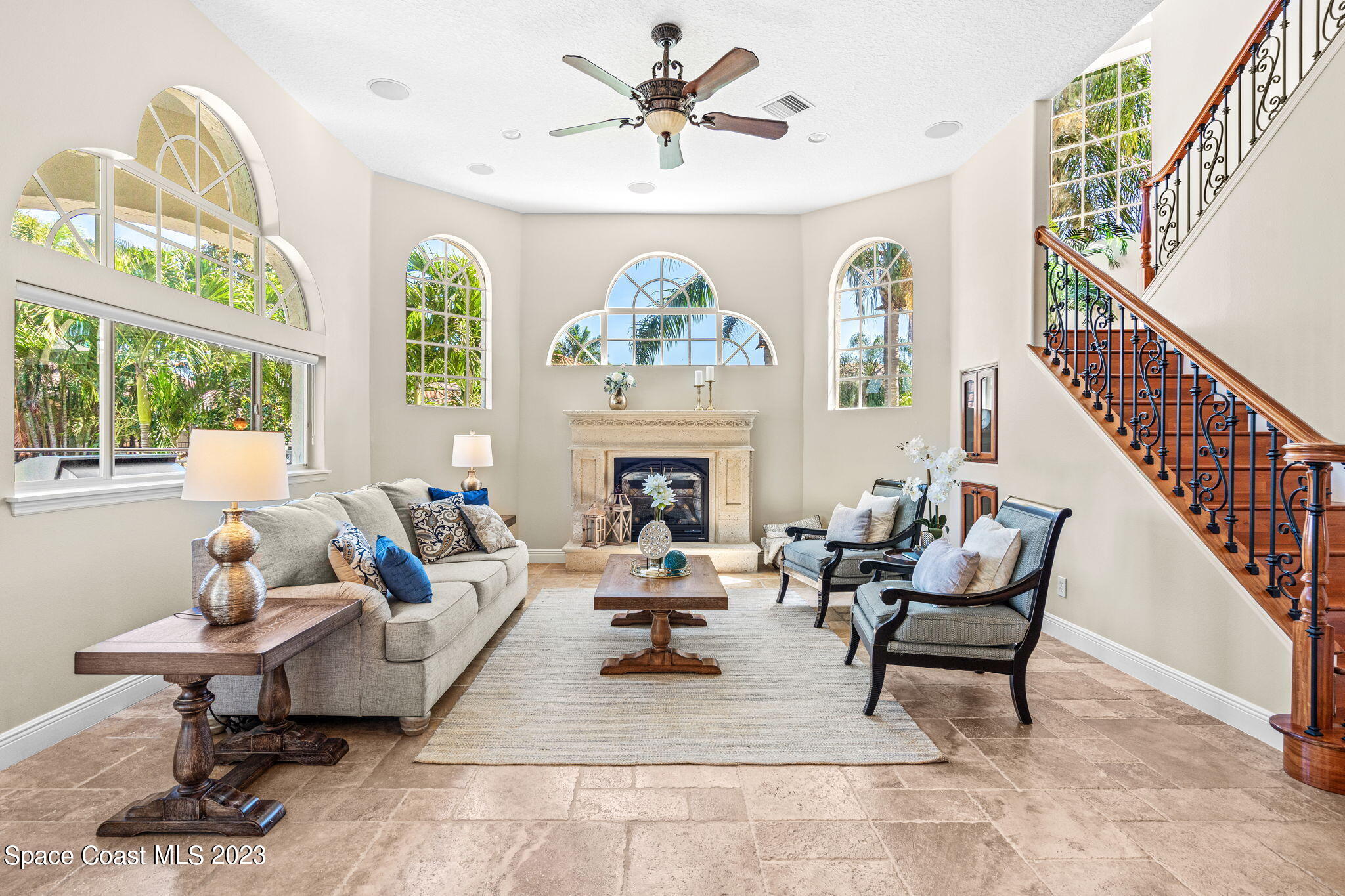 3308 Cappio Drive Melbourne, FL 32940 - Photo 11 of 42 a living room with furniture a fireplace and a chandelier