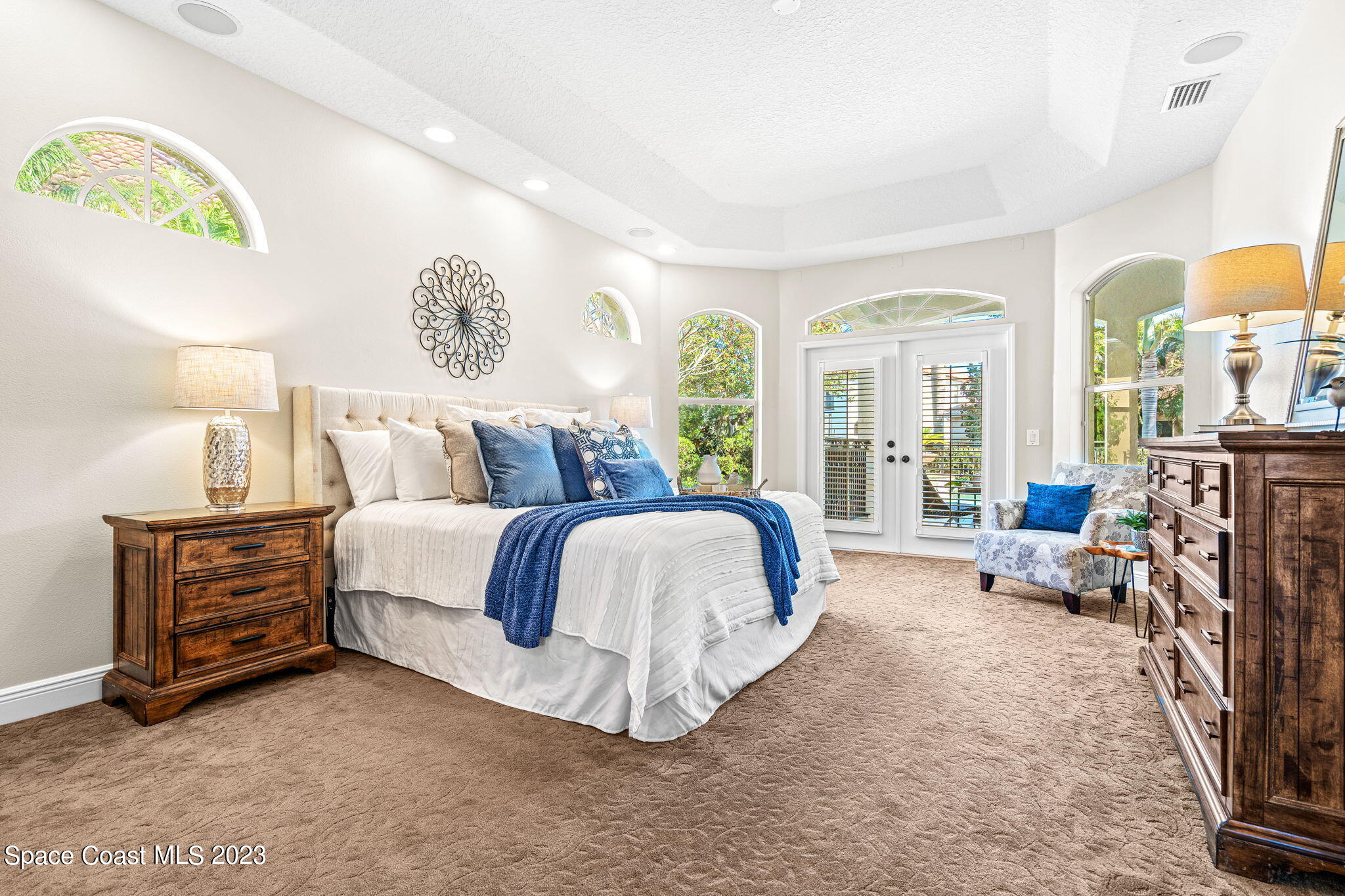 3308 Cappio Drive Melbourne, FL 32940 - Photo 13 of 42 a spacious bedroom with a bed couch and a large window