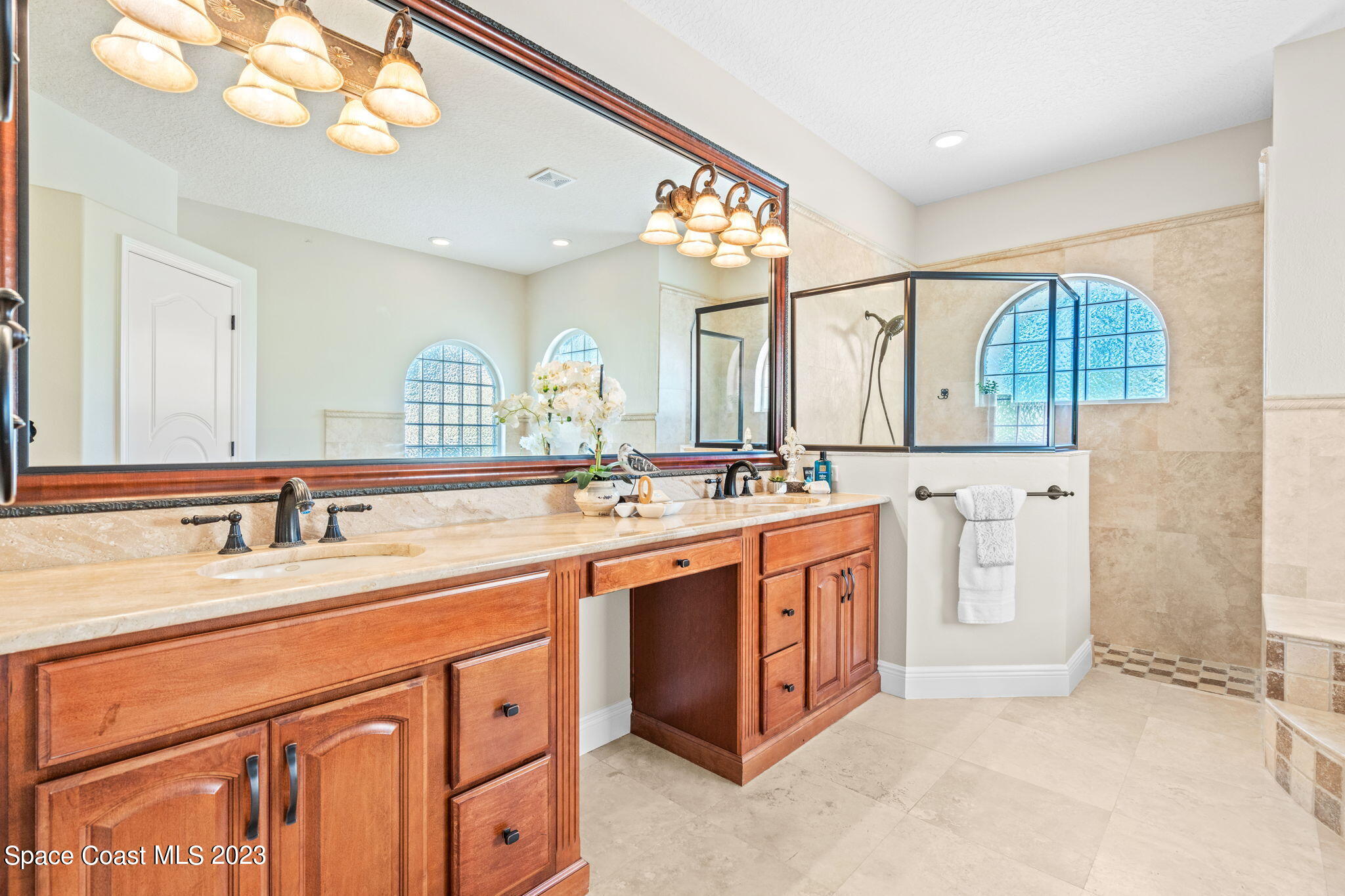 3308 Cappio Drive Melbourne, FL 32940 - Photo 16 of 42 a spacious bathroom with a sink a large mirror and a shower