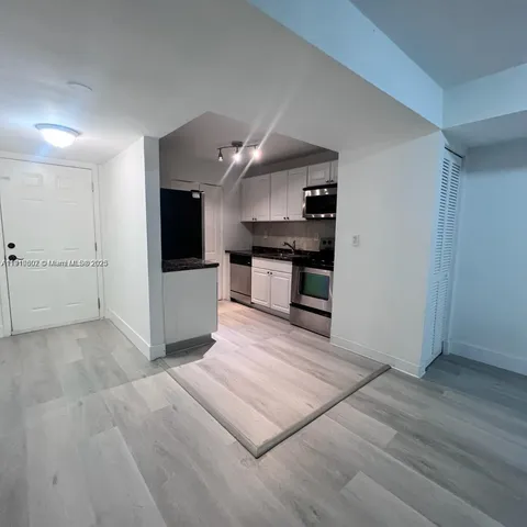 a view of kitchen with sink and refrigerator