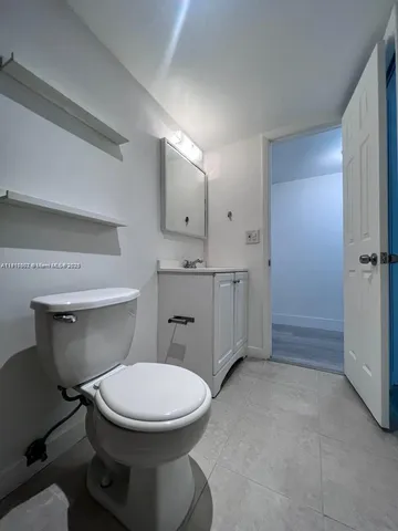 a bathroom with a toilet a sink and mirror