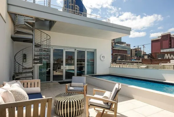 a view of a patio with couches table and chairs with wooden floor and fence