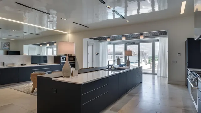 a large kitchen with kitchen island a sink appliances wooden floor and a counter top space