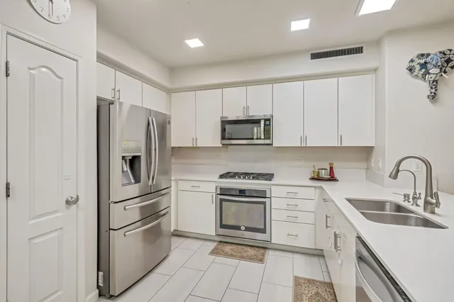 a kitchen with cabinets stainless steel appliances and a counter space
