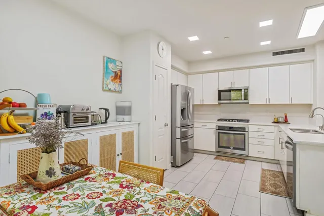 a kitchen with stainless steel appliances granite countertop a refrigerator and a stove top oven