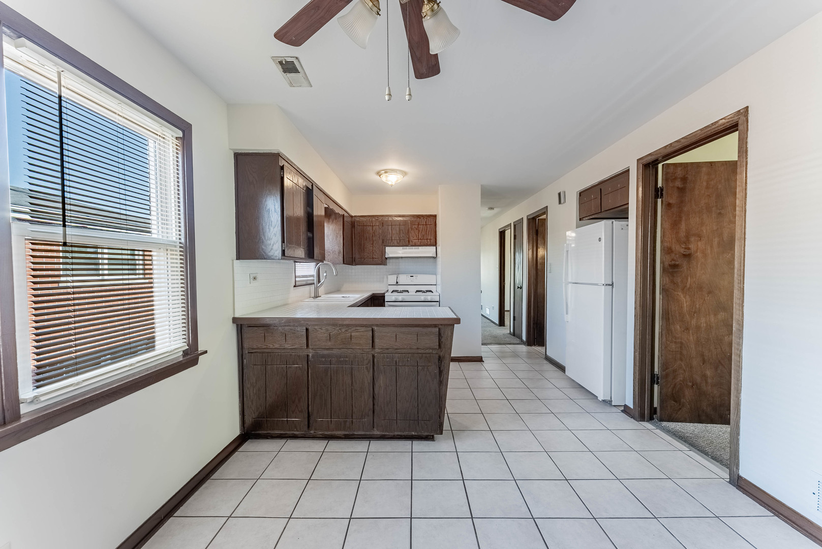 7560 Banks Street, Unit 2 Justice, IL 60458 - Photo 12 of 14 a large kitchen with a stove a sink dishwasher a refrigerator and a oven with wooden cabinets