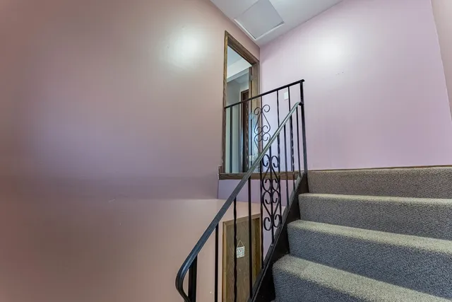 a view of staircase with wooden floor and white walls