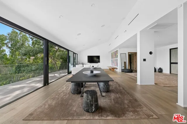 a living room with furniture flat screen tv and a floor to ceiling window