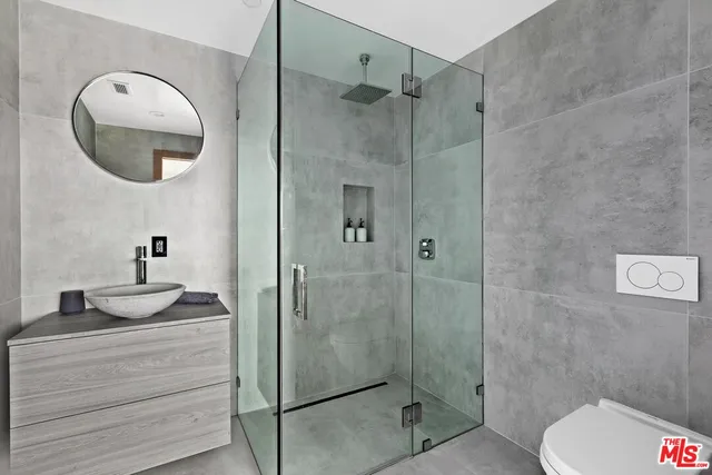 a bathroom with a sink a toilet and shower